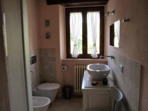 baño con lavabo y aseo y ventana en CASOLARE PANORAMICO IN UMBRIA Casetta en Città di Castello