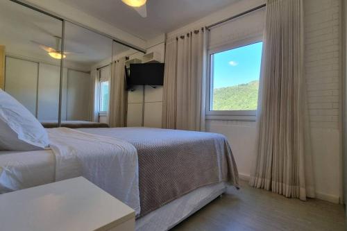1 dormitorio con cama y ventana grande en Aguas de Cachoeira, en Florianópolis