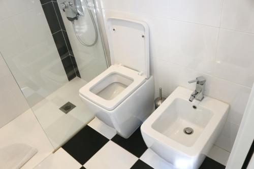 a white bathroom with a sink and a toilet at Dolce Loft in Bari