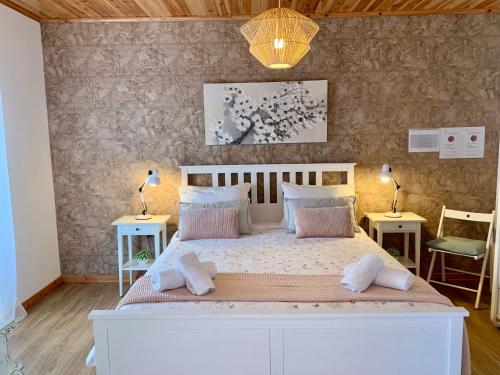 FeteirasにあるCasa do Priolo - Villaverde Azoresのベッドルーム1室(白い大型ベッド1台、テーブル2台付)