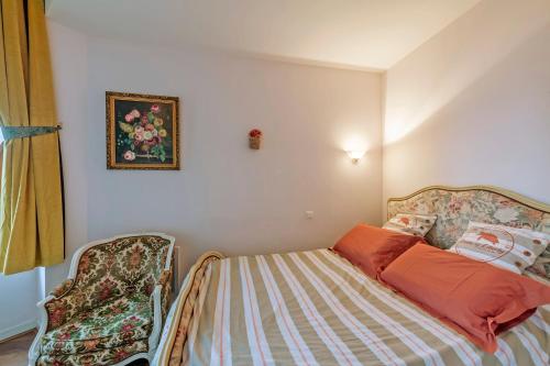 a small bedroom with a bed and a chair at château de Locquéran Pierres et filets bleus in Plouhinec