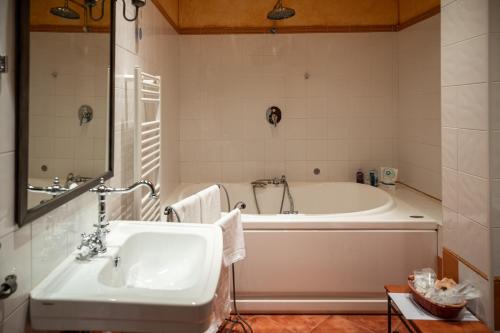 a bathroom with a tub and a sink at Jardin de la Abadia, Arroyo de la Encomienda in Valladolid