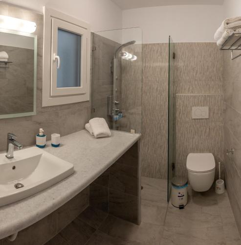 a bathroom with a sink and a shower and a toilet at Nissea Apartments in Naxos Chora