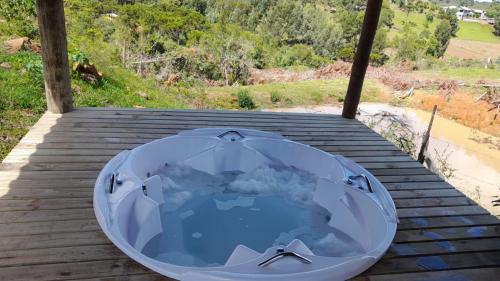 a hot tub sitting on top of a wooden deck at CHALÉ ESTÂNCIA OURO VERDE in Lages
