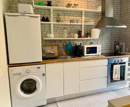 a kitchen with a washing machine and a microwave at Casa do Milhafre - Villaverde Azores in Feteiras