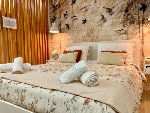 ein Schlafzimmer mit einem Bett mit Vögeln an der Wand in der Unterkunft Casa do Milhafre - Villaverde Azores in Feteiras