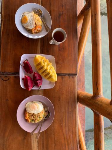 Floating Paradise في كاريمونجاوا: طاولة مع أطباق من الطعام وكوب من القهوة