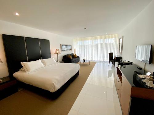 a bedroom with a bed and a living room at Vila Valverde Design Country Hotel in Luz