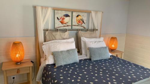 a bedroom with a bed with two lamps on tables at Casa do Açor - Villaverde Azores in Feteiras