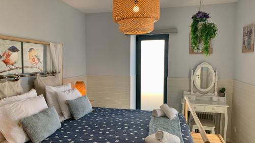 ein Schlafzimmer mit einem Bett und einem Spiegel in der Unterkunft Casa do Açor - Villaverde Azores in Feteiras