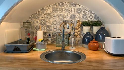 a kitchen counter with a sink and a counter top with a counter top at Casa do Açor - Villaverde Azores in Feteiras