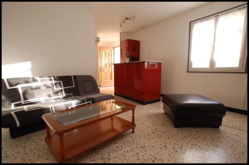 un salon avec un canapé et une table basse dans l'établissement Appartement entier, au calme, 2 personnes, à Mailhac