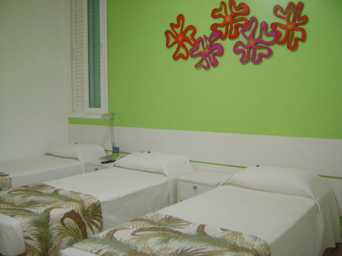 a room with three beds and a sign on the wall at Coqueiros Express Hotel in Maceió