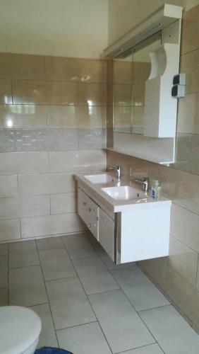 a bathroom with a sink and a toilet at HEBERTOGO Casablanca in Lomé