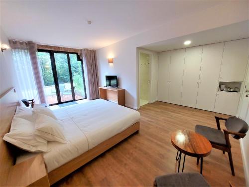 a bedroom with a large bed and a table and chairs at Quinta da Roda Hotel - Conforto e Tranquilidade no Gerês in Cela