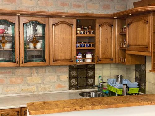 kuchnia z drewnianymi szafkami i zlewem w obiekcie Balaton7 Apartmanház - Badacsonytomaj Centrum w mieście Badacsonytomaj