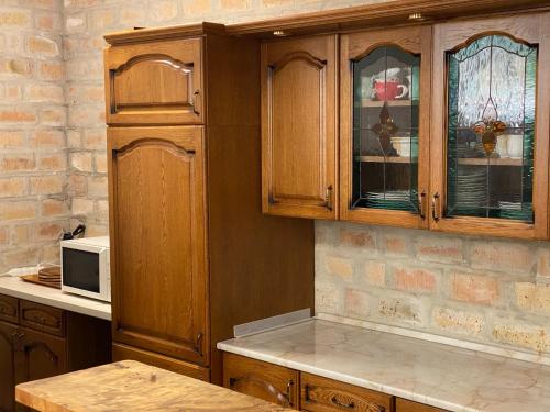 kuchnia z drewnianymi szafkami i mikrofalówką w obiekcie Balaton7 Apartmanház - Badacsonytomaj Centrum w mieście Badacsonytomaj