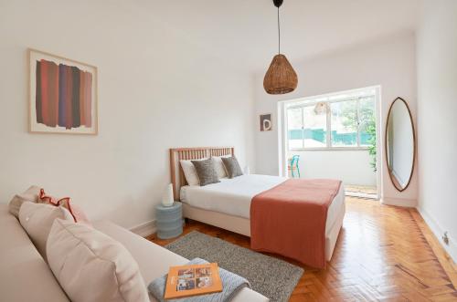 a living room with a bed and a couch at Light-Filled & Renovated Apartment, By TimeCooler in Lisbon