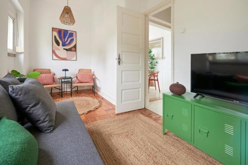 a living room with a couch and a flat screen tv at Light-Filled & Renovated Apartment, By TimeCooler in Lisbon