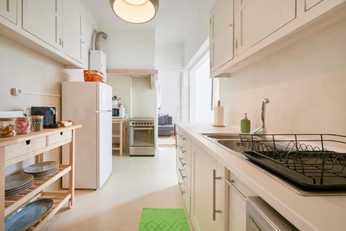a kitchen with white cabinets and a white refrigerator at Light-Filled & Renovated Apartment, By TimeCooler in Lisbon