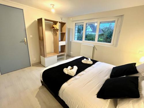 1 dormitorio con 1 cama grande y 2 toallas. en Subra YourHostHelper, en Merville-Franceville-Plage