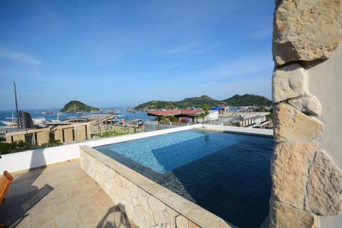 einem Pool an der Seite eines Gebäudes in der Unterkunft Harbour Komodo Hotel in Labuan Bajo