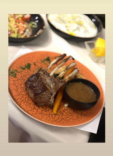 a plate of food with a steak and dipping sauce at Fly inn Hotel Lounge in Machelen
