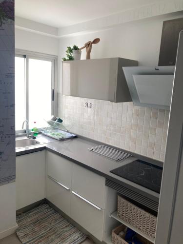 a kitchen with white cabinets and a sink at Cactus Home Penthouse in La Garita
