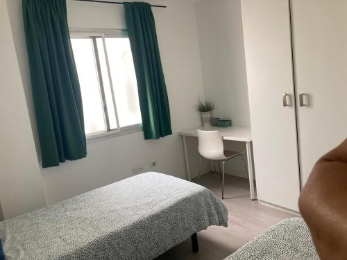 a bedroom with a bed and a desk and a window at Cactus Home Penthouse in La Garita