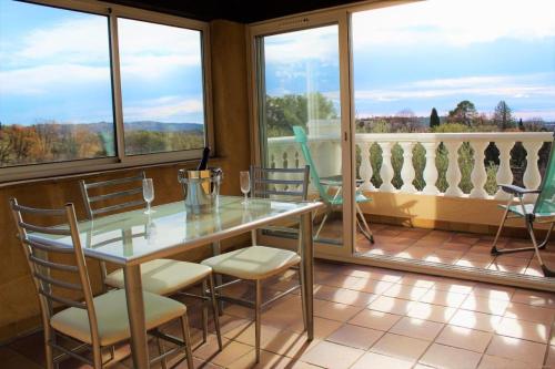 une salle à manger avec une table, des chaises et des fenêtres dans l'établissement Mas d'eucalyptus, à Grasse