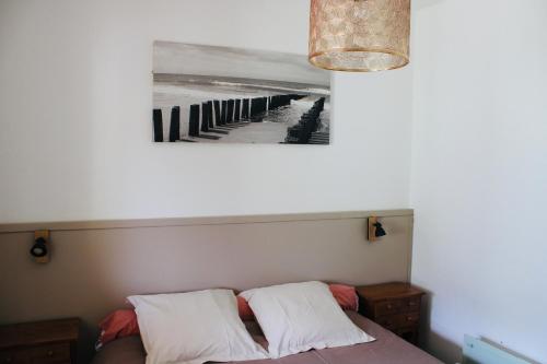 a bed with two pillows and a picture of a pier at Villa I Bugni in Sisco
