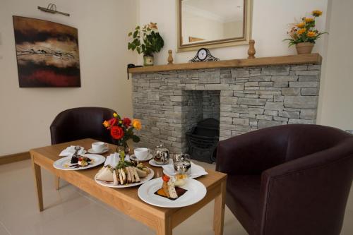 un tavolo con piatti di cibo e un camino di Deebert House Hotel a Kilmallock