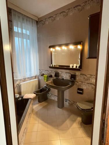 a bathroom with a sink and a toilet and a mirror at Piazza Italia Charming Sea Apartments in Chioggia