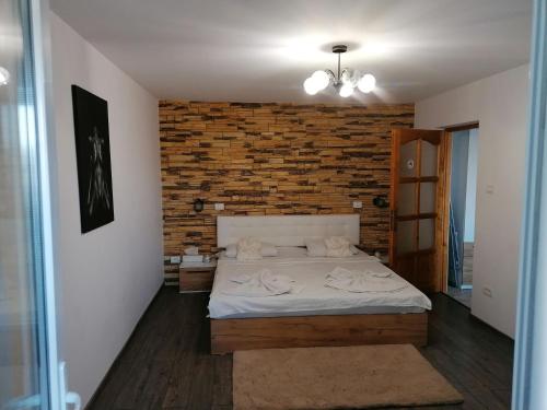 a bedroom with a bed and a brick wall at Insomnia Studio in Drobeta-Turnu Severin