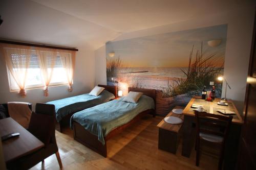 Zimmer mit 2 Betten, einem Tisch und einem Sofa in der Unterkunft LANDHAUS KLAMBAUER Ferienapartments Thermennähe St Martins Therme in Frauenkirchen