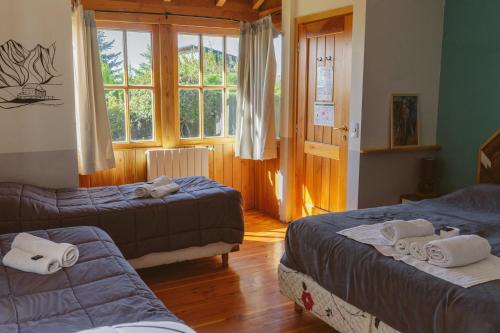 a hotel room with two beds and a window at Selva India Suites in San Carlos de Bariloche
