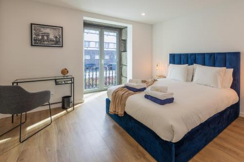 a bedroom with a bed with a desk and a window at PDL Apartment in Ponta Delgada