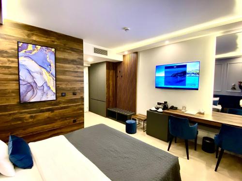 una camera d'albergo con letto, scrivania e TV di IG Hotel a Gornji Milanovac