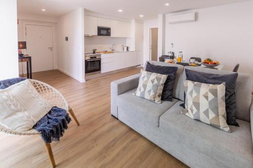 a living room with a couch and a kitchen at PDL Apartment in Ponta Delgada