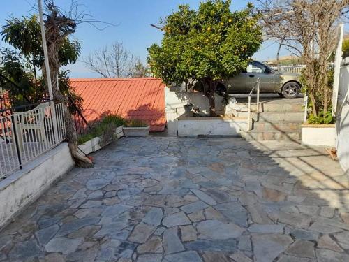 a stone driveway with an orange roof and a car at Vacation House Dionysia in Aigio