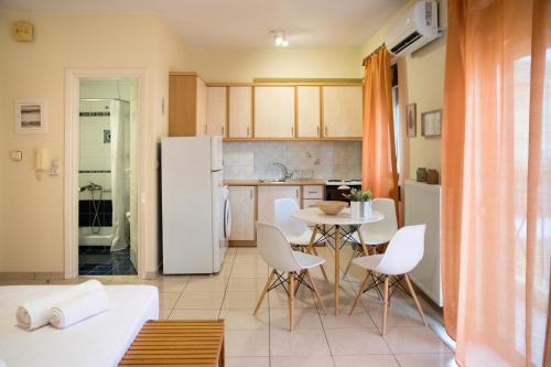 eine Küche und ein Wohnzimmer mit einem Tisch und Stühlen in der Unterkunft Sunny City Studio in Kalamata