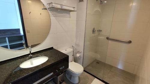 een badkamer met een wastafel, een toilet en een spiegel bij Flat Vista mar + Limpeza | R627 in Maceió
