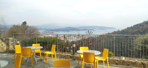 a group of tables and yellow chairs on a balcony at Agriturismo La Pietra 1 e La Pietra 2 in La Spezia