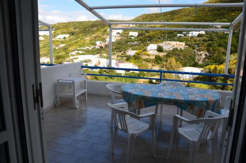balcón con mesa, sillas y vistas en Ponza Holiday Homes - Cala Feola, en Ponza