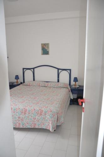 1 dormitorio con 1 cama y 2 mesas con lámparas en Ponza Holiday Homes - Cala Feola, en Ponza