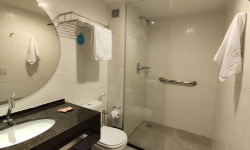 y baño con lavabo, aseo y espejo. en Flat Frente Mar + Limpeza | R206, en Maceió