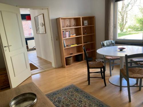 a living room with a table and chairs and a book shelf at Ostsee Hafenkoje - Lübeck-Travemünde Priwall in Lübeck