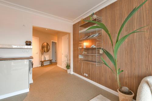 una sala de estar con una planta en la pared en Oostending, en Ostende