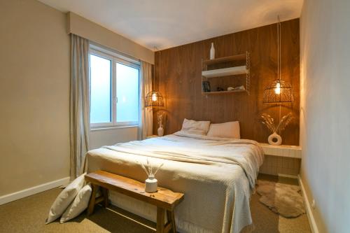 Un dormitorio con una cama y una mesa y una ventana. en Oostending, en Ostende