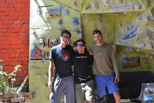 three men standing in front of a climbing wall at Monkeywasi Climbing Hostel in Huaraz